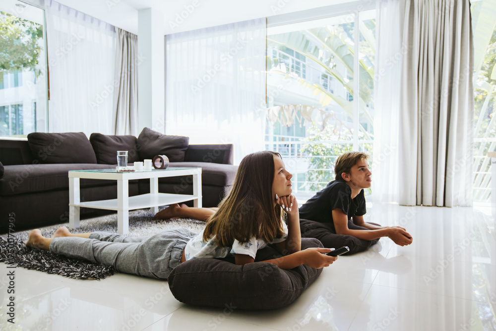 Teenagers watching tv while sitting on couch Teenagers watching tv while sitting on couch