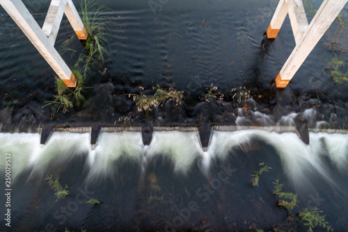 Foundation poles of the bridge over the river and spillway photo