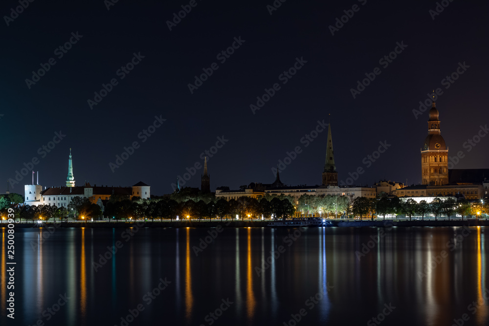 Panoramic night view on old Riga the capital of Latvia city from left bank of Daugava river. Its unique with a medieval and Gothic architecture.