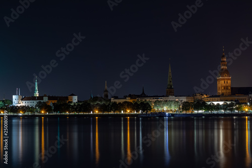 Panoramic night view on old Riga the capital of Latvia city from left bank of Daugava river. Its unique with a medieval and Gothic architecture.