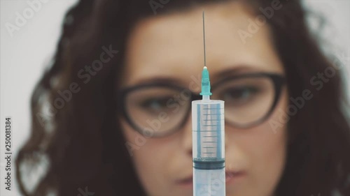 Doctor or nurse draws a solution in a syringe from a vial in a hospita. Doctor with a medical needle in an ampoule getting ready for a patient injection.