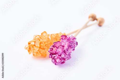 Rock candy or orange and purple sugar candy isolated on white background. Crystallized sugar. Nabat or rock candy is often used as a type of candy, or used to sweeten milk, or dissolved in tea.
