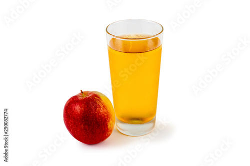 On a white background apple juice in a glass next to an apple.