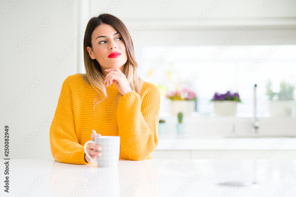 Young beautiful woman drinking a cup of coffee at home serious face thinking about question, very confused idea Young beautiful woman drinking a cup of coffee at home serious face thinking about question, very confused idea