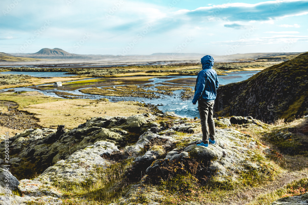 young woman looking at majestic icelandic landscape