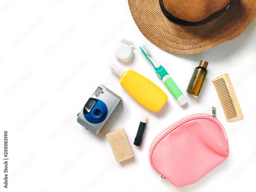 Flat lay photo sun hat, camera, yellow sunscreen lotion spray, toothbrush, dental floss, shampoo in small package, lips balm, soap bar cosmetic Travel cosmetics for hair, skin care Stock Photo