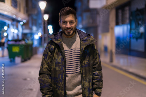 Young handsome man possing and smiling. Street style at night