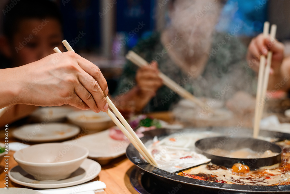 People taking food with chopsticks People taking food with chopsticks