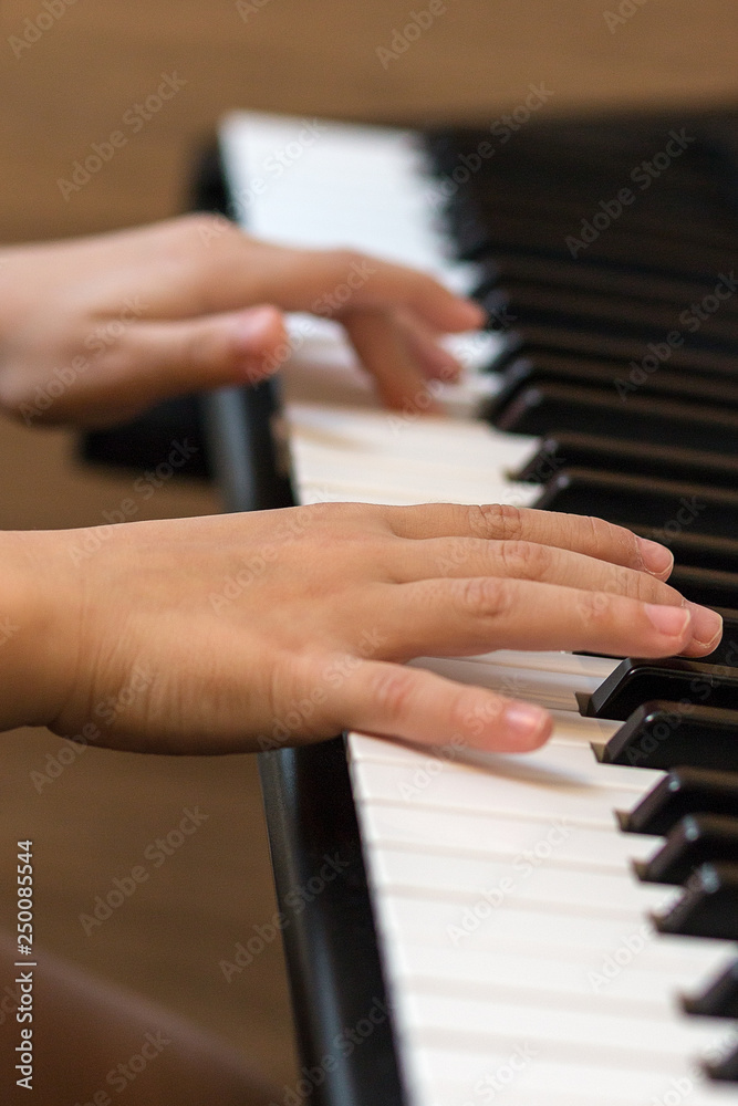 Hands of the child on the piano keys. Selective focus. Hands of the child on the piano keys. Selective focus.