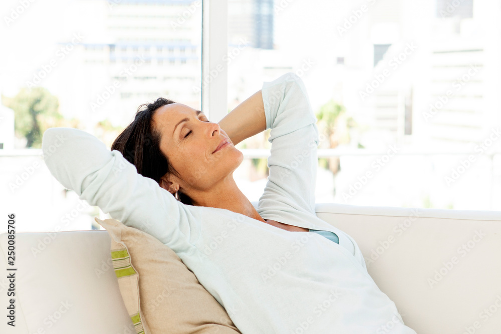Woman relaxing at home on sofa - beautiful brunette closing eyes Woman relaxing at home on sofa - beautiful brunette closing eyes