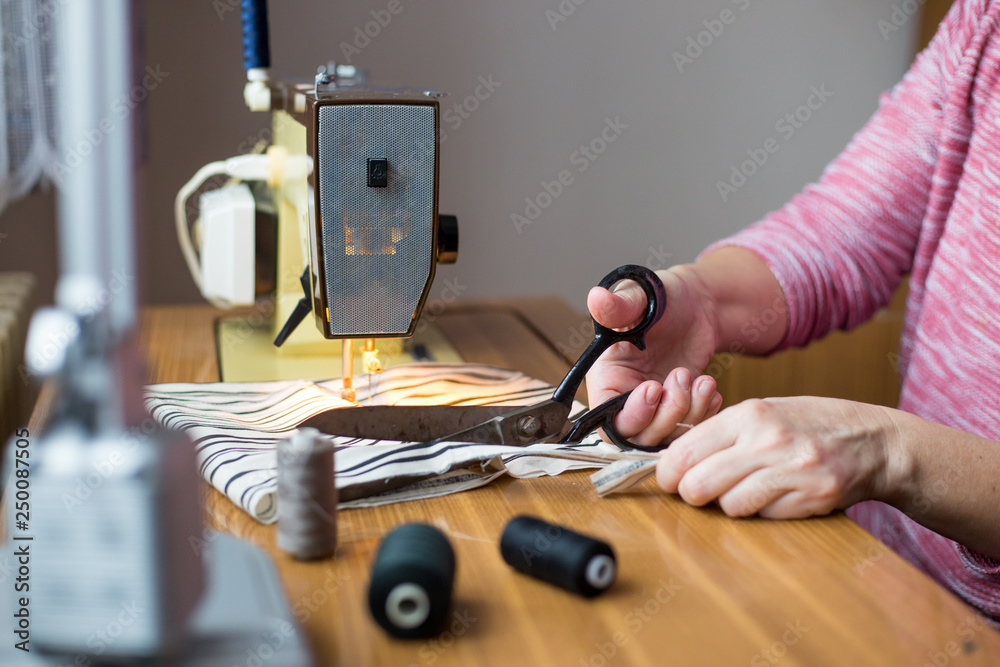 pattern scissors tape measure and a sewing machine. Dressmaker cuts dress pattern scissors tape measure and a sewing machine. Dressmaker cuts dress