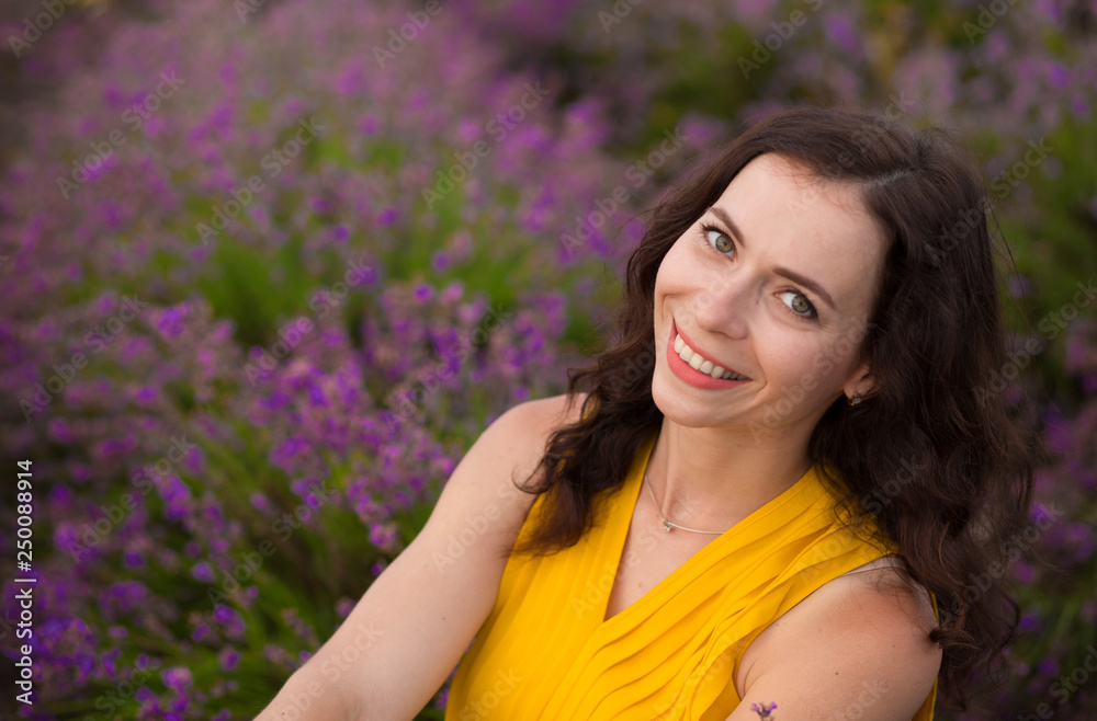 Summer portrait of young attractive woman in yellow dress sitting in blooming violet lavander field. Summer portrait of young attractive woman in yellow dress sitting in blooming violet lavander field.