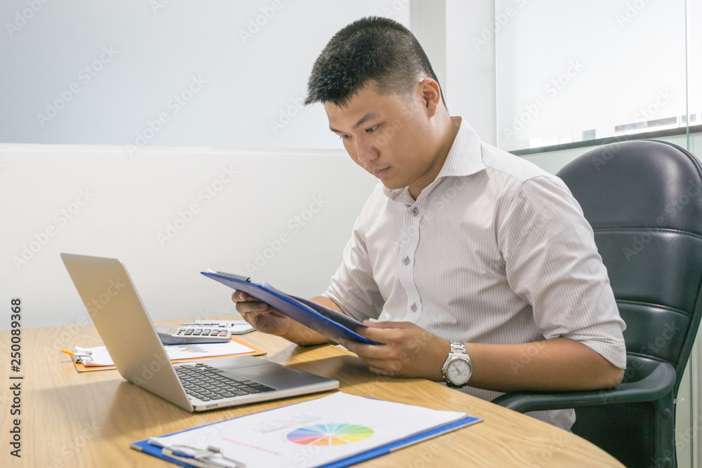 Young office man reading financial document in the company
