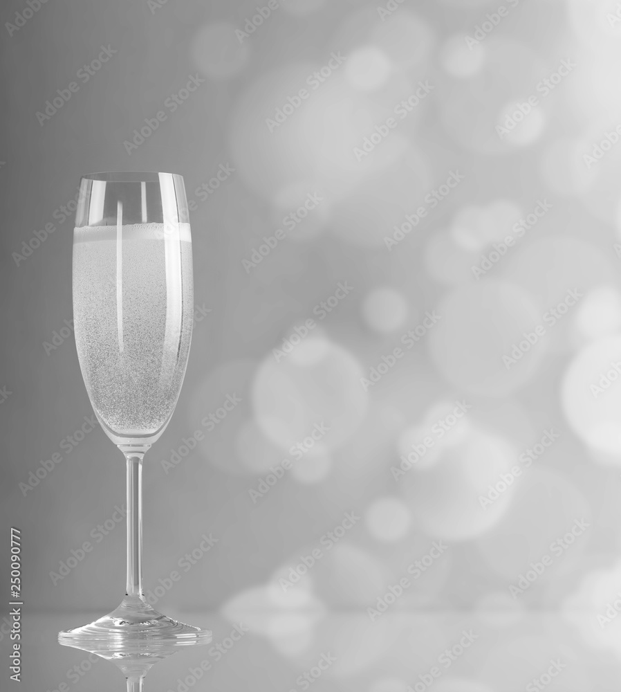 Glass of champagne in a black-and-white color against the bright circles Glass of champagne in a black-and-white color against the bright circles