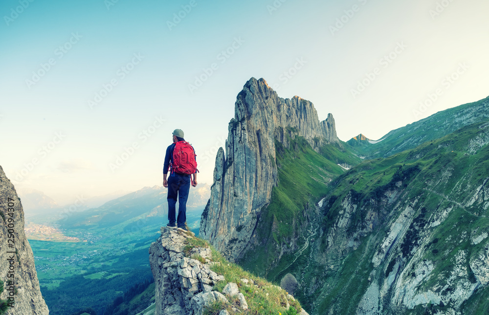 Obraz premium Tourist on the high rocks background. Sport and active life concept. Adventure and travel in the mountain region in the Switzerland mountains.