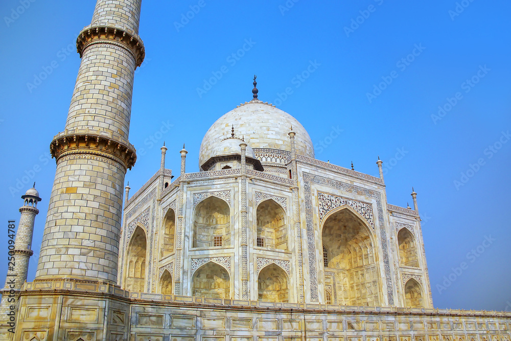 Close view of Taj Mahal against blue sky, Agra, Uttar Pradesh, India. It was commissioned in 1632 by the Mughal emperor Shah Jahan to house the tomb of his favourite wife Mumtaz Mahal.