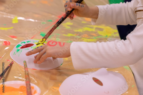 kid painting and drawing on mask.