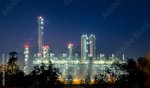 petrochemical and petroleum plant industry with refinery stack and tank farm in in chemical industrial zone at night after sunset