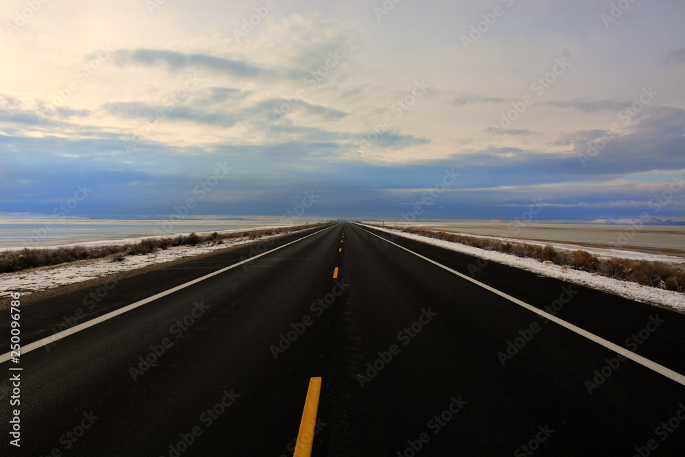 Cold Winter Road across Lake into Horizon Sky