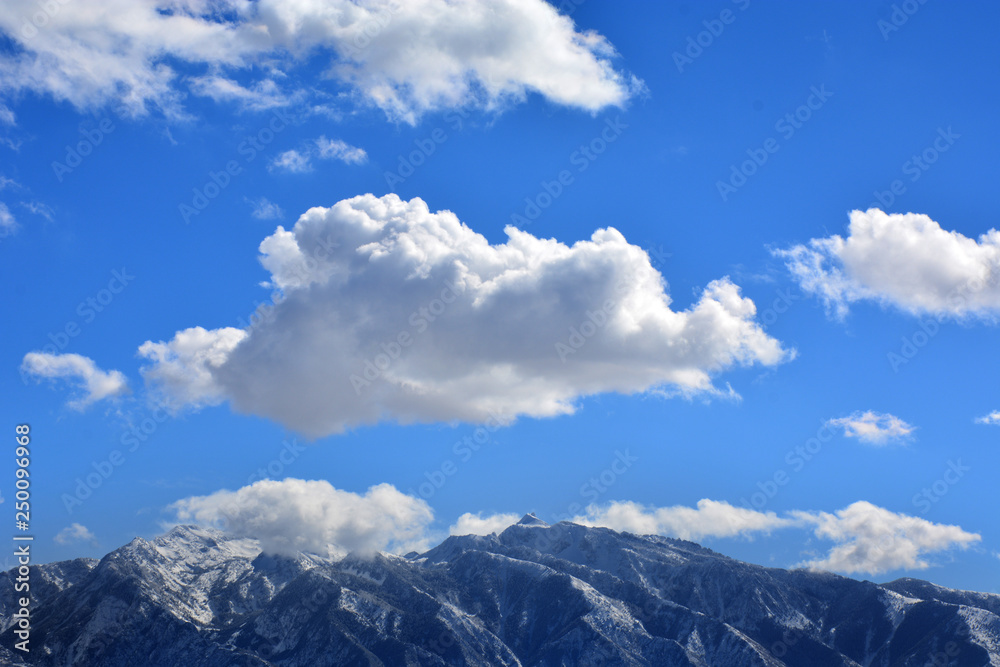 Clouds and Blue Skies over Snowy Mountain Range in Utah