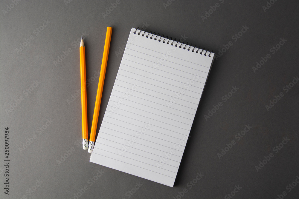 Notepad or notebook with pencil on gray background. Concept for education, business with copy space. Mock up. Notepad or notebook with pencil on gray background. Concept for education, business with copy space. Mock up.