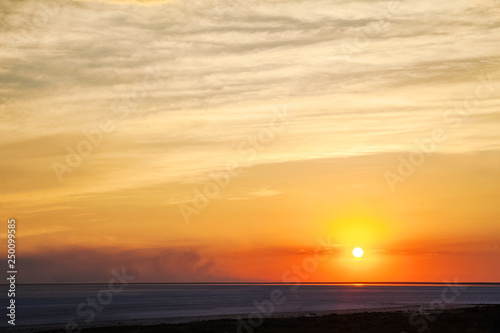 Beautiful natural textural background of the sunset on the lake, river. Salt lake Elton, Russia, sunset on the water