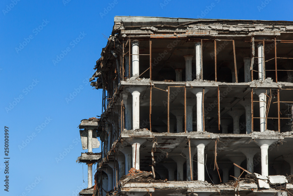 Old building for demolition on a background of clean blue sky