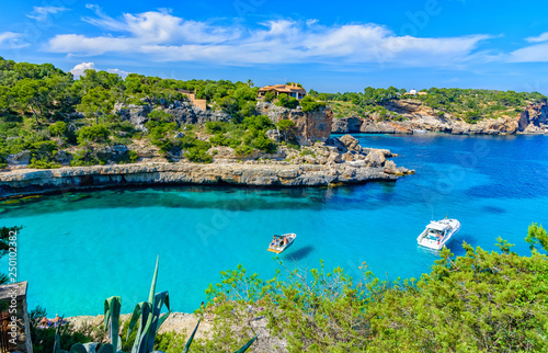 Summer vacation scene with sailboats on turquoise clean water on Mallorca Island near Cala Llombards beach