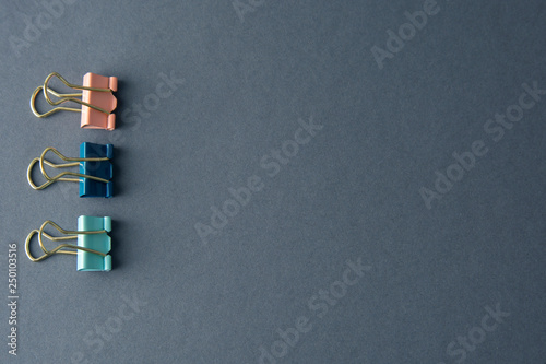 Colorful binder clips isolated on gray background, work space, work table, copy space.