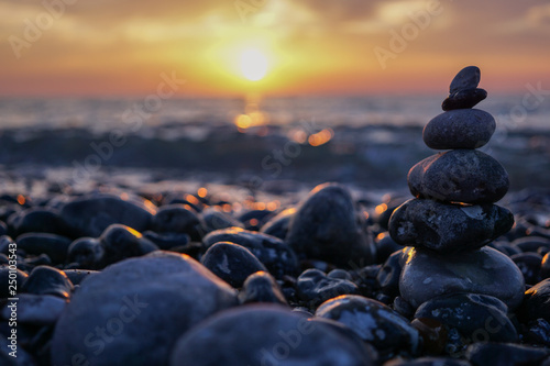 Sunset and stone sculpture pebble - Zen relaxation and harmony. Near Dieppe, France