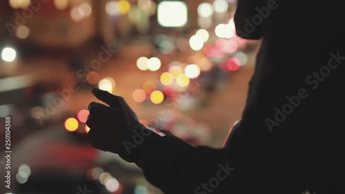Silhouette of man in night city unblock his smarphone photo