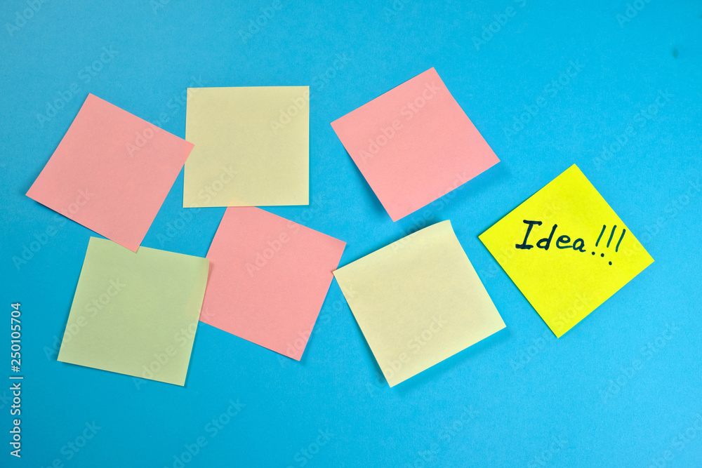 Many colored empty office stickers on a blue background and one separately . Mock-up Many colored empty office stickers on a blue background and one separately . Mock-up