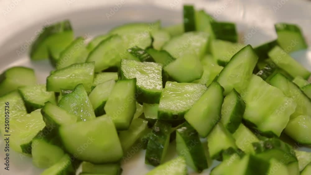 Slices of fresh green cucumber on a white plate Slices of fresh green cucumber on a white plate