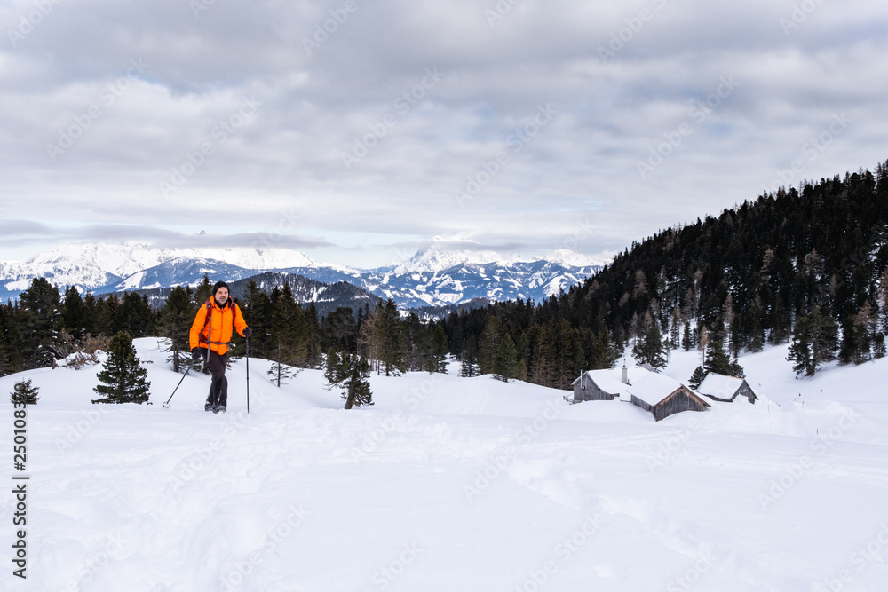 Man snowshoeing on Scheibelalm in Hohentauern view to Ennstaler Alps