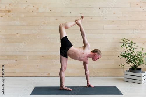 Sporty man practicing yoga on yoga class photo