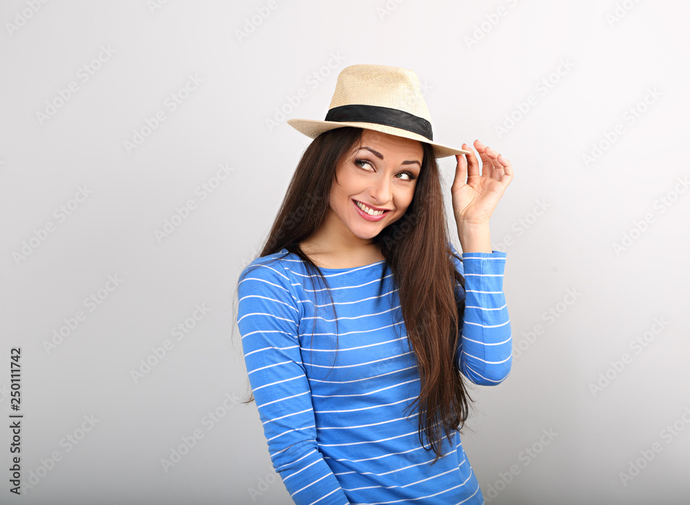 Friendly funny woman thinking in blue top and straw hat looking up on toned blue color copy space Friendly funny woman thinking in blue top and straw hat looking up on toned blue color copy space