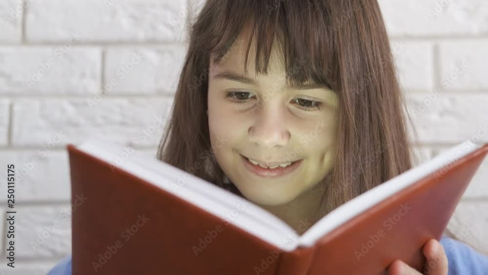 Happy schoolgirl with a book. Happy little girl reads a book. Reading child. Happy schoolgirl with a book. Happy little girl reads a book. Reading child.