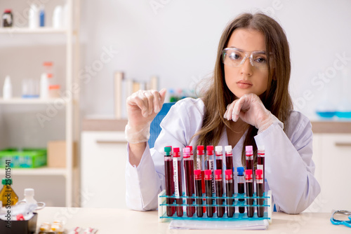 Young beautiful lab assistant testing blood samples 