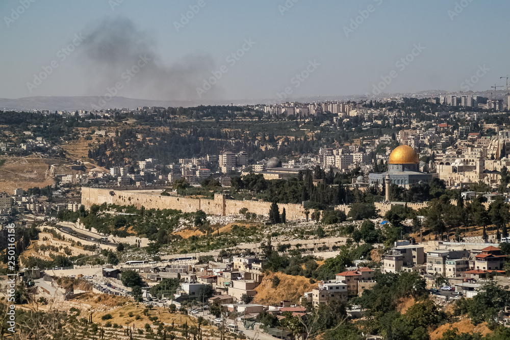 Overview of landscape of Old City of Jerusalem with smoke over the mountains and copy space above