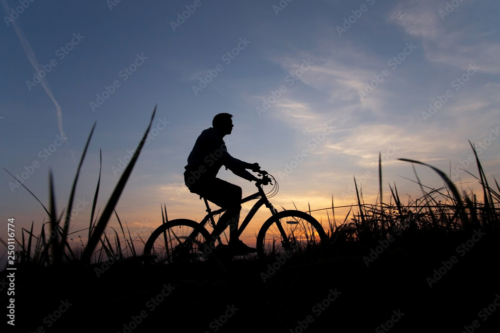 Silhouette of a cyclist against the sunset sky, copy space Silhouette of a cyclist against the sunset sky, copy space