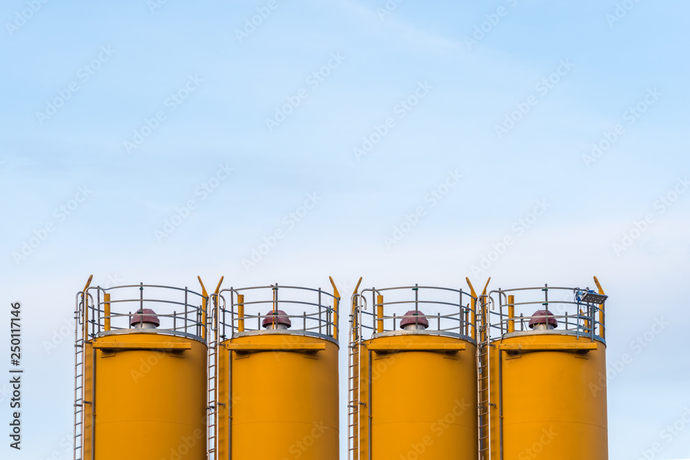 Obraz premium Four silos in front of blue sky