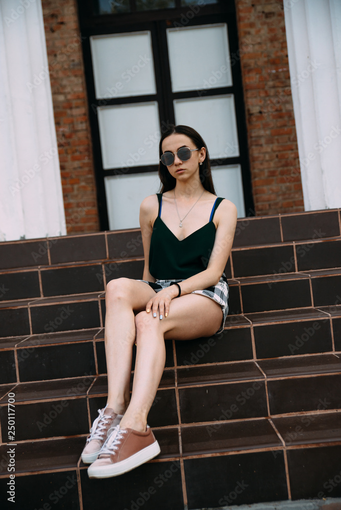 Sexy girl in sunglasses t-shirt and short shorts near the columns Stock  Photo | Adobe Stock
