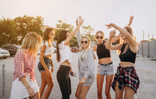 Six young women dance in a car park