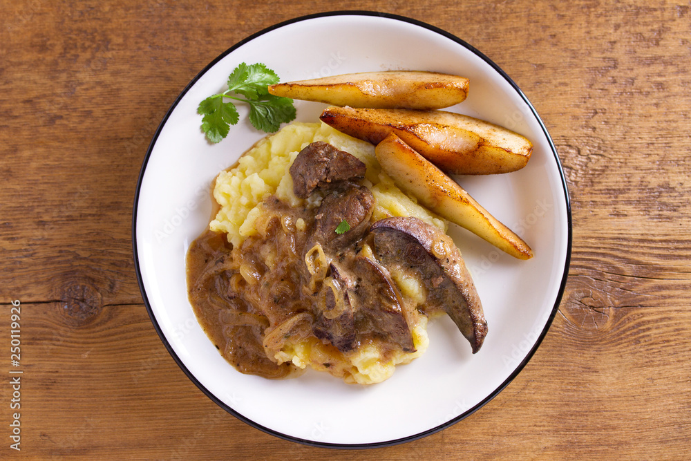 Beef liver with pears and mashed potato. View from above, top studio shot Beef liver with pears and mashed potato. View from above, top studio shot