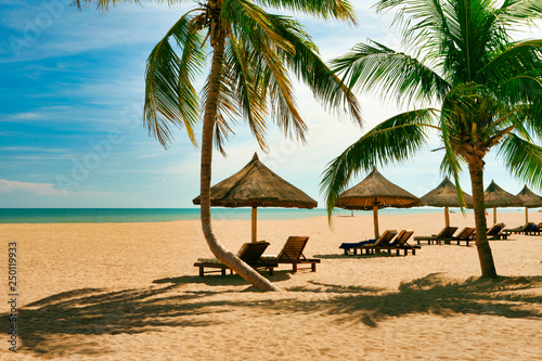 Many empty sun loungers on the deserted beach of Hainan Island.