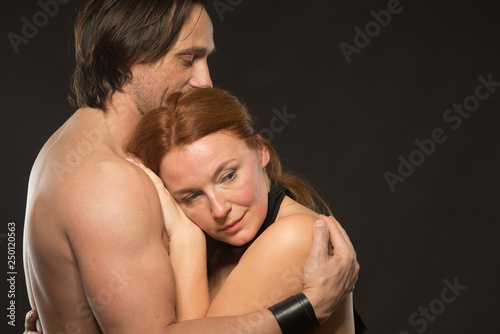 Portrait of calm bare shouldered woman feeling comfortable in her husbands arms