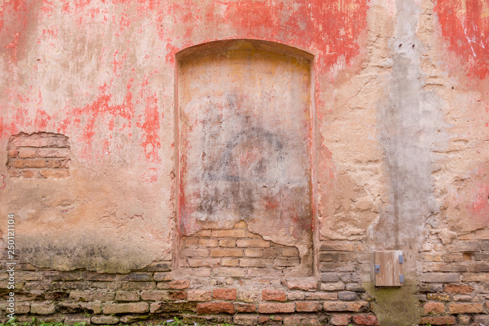 Old weathered painted wall background texture. Red dirty peeled plaster wall with falling off flakes of paint. Old weathered painted wall background texture. Red dirty peeled plaster wall with falling off flakes of paint.