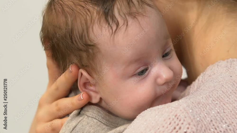 Beautiful young lady singing little baby to sleep, holding carefully in arms Beautiful young lady singing little baby to sleep, holding carefully in arms