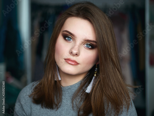 Young beautiful woman with professional make up and hairstyle with domestic room blurry background