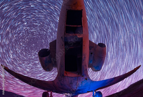 Old airplane back view. Star trails.